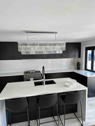 a kitchen with a sink and a counter with chairs at Ultimate waterfront Mansion in Gold Coast