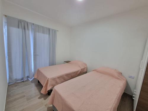 a room with two beds and a window at Casa Silva in Las Grutas