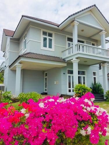 a house with pink flowers in front of it at Bougainviella - Sealinks Mũi Né - chuỗi biệt thự liền kề in Phan Thiet