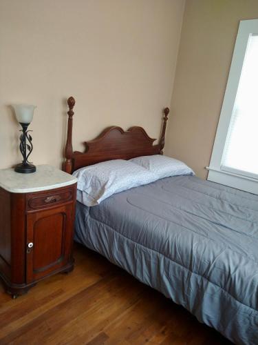 a bedroom with a bed and a wooden night stand at Casita De Agua Encanto in Truth or Consequences