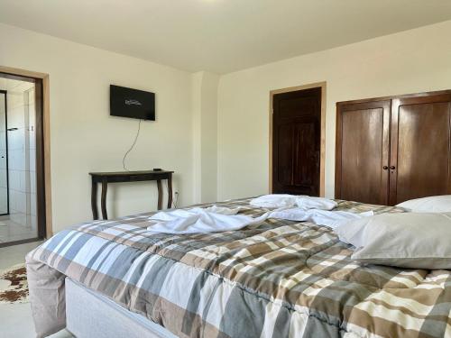 una camera con un letto con una coperta a scacchi di Suíte na casa amarela a Pomerode