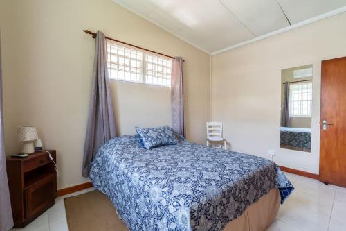 a bedroom with a blue bed and a window at Paddock Road in Bridgetown