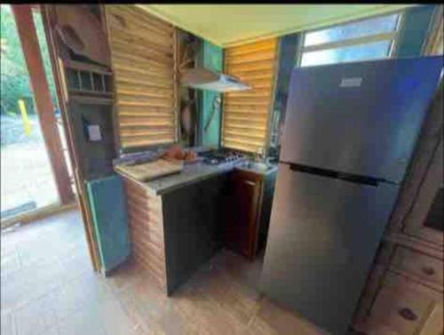 a kitchen with a stainless steel refrigerator and a stove at Villa vista del manantial in Concepción de La Vega