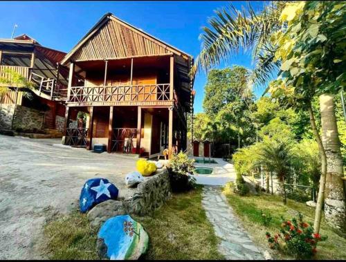 a house with a palm tree in front of it at Villa vista del manantial in Concepción de La Vega