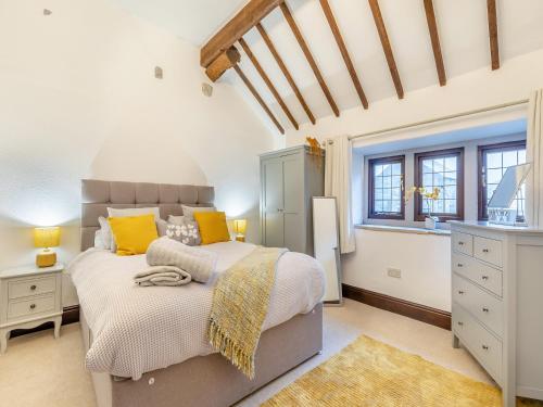 a bedroom with a large bed with yellow pillows at Dale House Farm - Uk46033 in Monyash