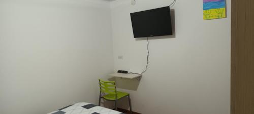 1 dormitorio con 1 cama y TV en la pared en Casa cerca al centro de la ciudad cupo para 6 personas, en Manizales