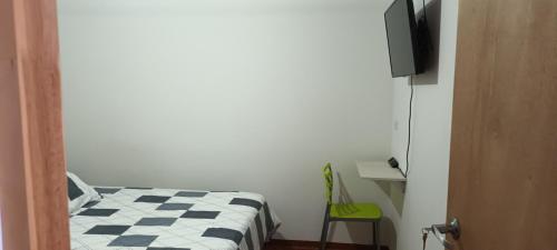 a bedroom with a bed and a desk and a television at Casa cerca al centro de la ciudad cupo para 6 personas in Manizales