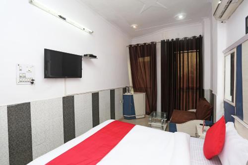 una camera con letto e TV a schermo piatto di OYO Hotel Dev a Palwal