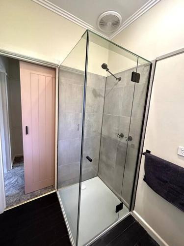 a shower with a glass door in a bathroom at Shepparton House in Shepparton