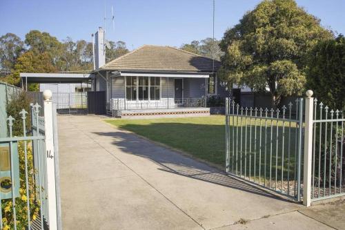 a white fence in front of a house at Shepparton House in Shepparton