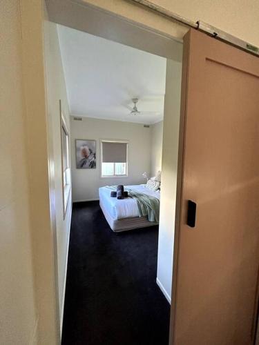 a room with a bed and a room with a window at Shepparton House in Shepparton