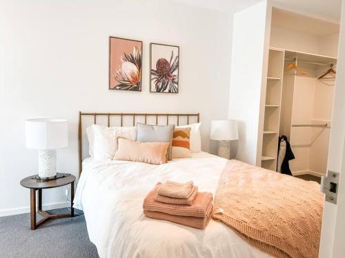 a bedroom with a large bed with a towel on it at Metropol - CBD pool Sleeps 7 in Canberra