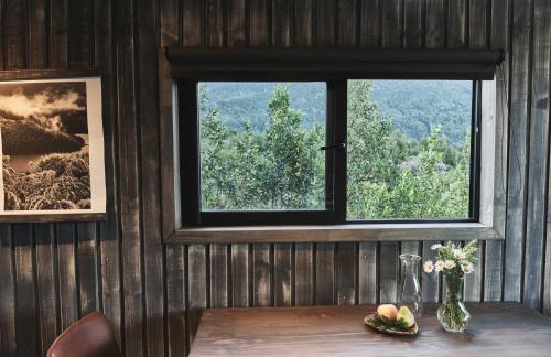 a window in a room with a table with flowers at MA PU LODGE Futaleufu in Futaleufú