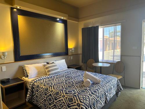 The Tower Hotel في كالغورلي: غرفة نوم يوجد فوقها سرير و شاشة كبيرة