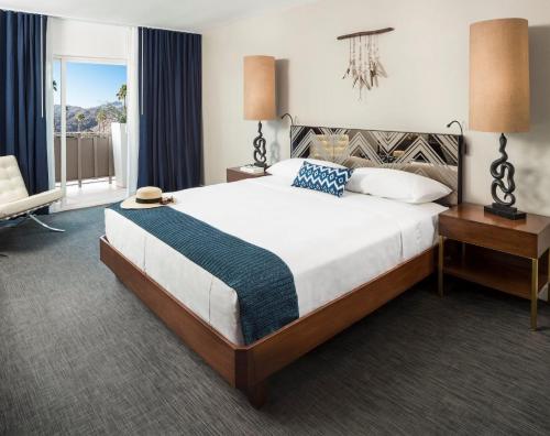 a bedroom with a large bed and a window at V Palm Springs in Palm Springs