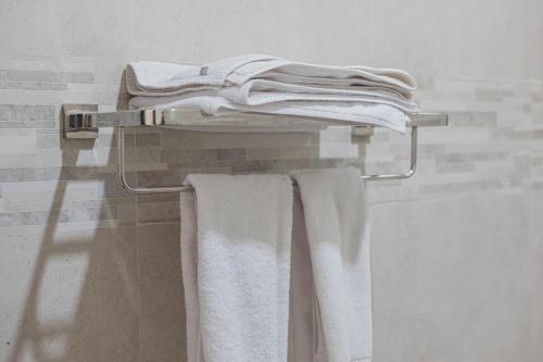 un toallero con toallas blancas en el baño en Wisata Bintang Hotel, en Ubud