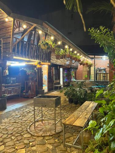a restaurant with a wooden table and a bench at Nhà Sàn Bên Suối in Buôn Ðũng