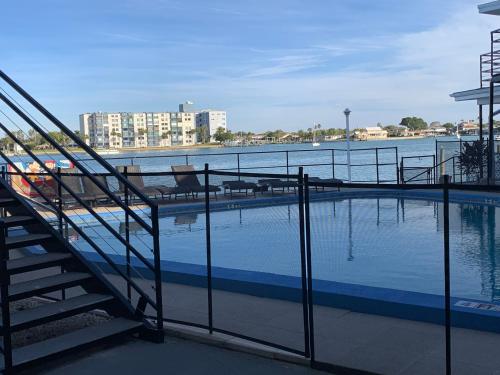 una piscina con escaleras junto a un cuerpo de agua en By the Beach Rentals, en Clearwater Beach