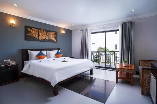 ein Schlafzimmer mit einem großen Bett und einem großen Fenster in der Unterkunft Ratana Angkor Hotel in Siem Reap