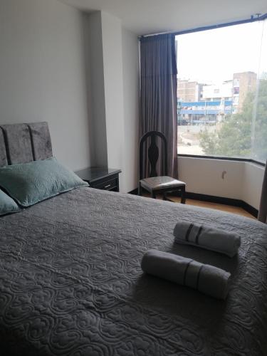 a bedroom with a large bed with a large window at Moderno apartamento para huespedes in Ipiales