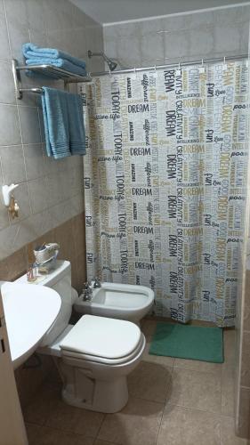 a bathroom with a toilet and a shower curtain at Espacio B in Chivilcoy