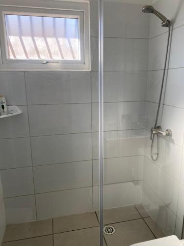 a shower with a glass door in a bathroom at Cómoda casa nueva 3 D 2 B in La Serena