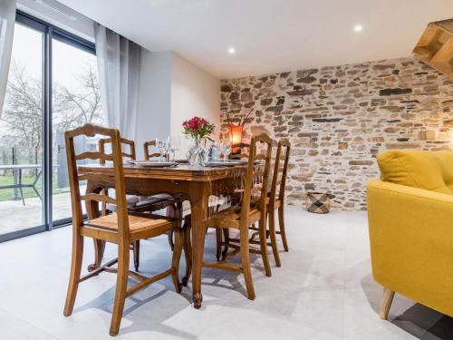 une salle à manger avec une table et des chaises en bois dans l'établissement Gîte familial rénové près du Canal de Nantes avec jardin, terrasse, wifi et chambres mansardées - FR-1-306-1263, à Nort-sur-Erdre