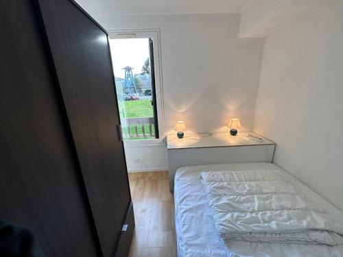 ein kleines Schlafzimmer mit einem Bett und einem Fenster in der Unterkunft Appartement Seignosse, 2 pièces, 4 personnes - FR-1-239-1008 in Seignosse