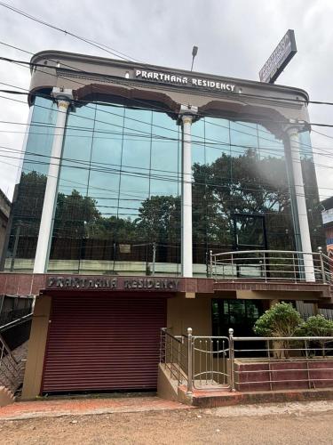 a large glass building with a sign on it at PRARTHANA RESIDENCY in Attingal