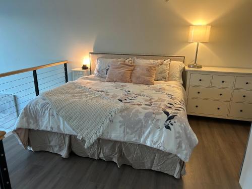 a bedroom with a bed and a dresser at Modern top-floor 1-bedroom loft with free parking in Vancouver