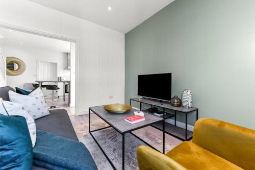 ein Wohnzimmer mit einem Sofa und einem TV in der Unterkunft Modern and Hearty House in Enfield