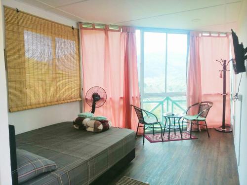 a bedroom with a bed and a table and chairs at Nulu View Cabin in Kundasang