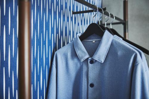a blue shirt is hanging on a hanger at voco Osaka Central by IHG in Osaka