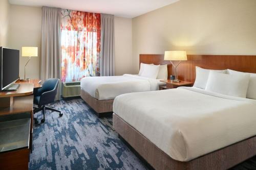 ジャクソンにあるFairfield Inn & Suites by Marriott Jacksonのベッド2台、デスク、テレビが備わるホテルルームです。