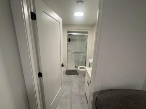 a white bathroom with a toilet and a sink at Cozy Apartment close to Airport in Dieppe