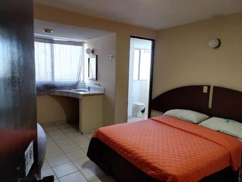 1 dormitorio con 1 cama y baño con lavamanos en Hotel Tres Torres en Morelia