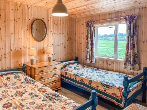 a bedroom with two beds and a window at Langston Farm Chalet in Shillingstone