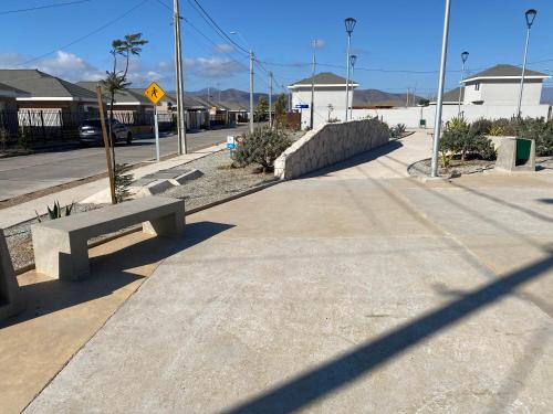 a bench sitting on the side of a street at Cómoda casa nueva 3 D 2 B in La Serena