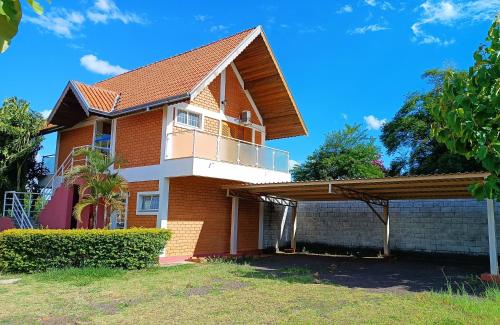 a red brick house with a balcony at Pousada Mandala Botucatu in Botucatu