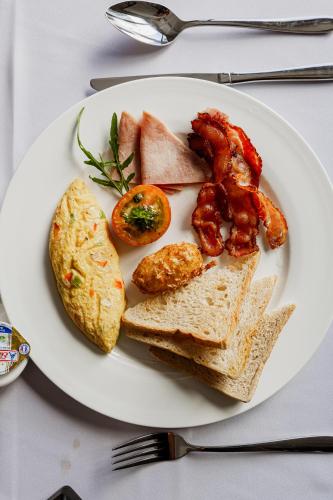 a plate of food with bacon eggs bread and toast at Ratana Angkor Hotel in Siem Reap
