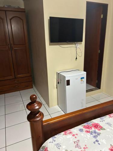 a room with a small refrigerator and a flat screen tv at casa familiar da gilvana in São Gabriel