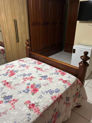 a bed with a floral quilt on it in a room at casa familiar da gilvana in São Gabriel