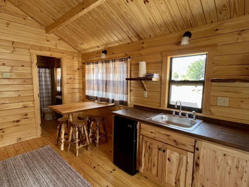 una cocina en una cabaña de madera con fregadero y ventana en Zion Canyon Cabins, en Springdale