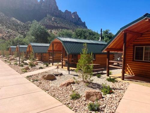 een blokhut met een berg op de achtergrond bij Zion Canyon Cabins in Springdale