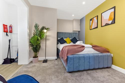 um quarto com 2 camas e uma parede amarela em Stylish and Snug Studio em Enfield