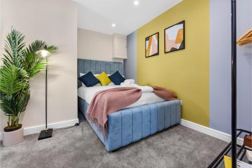 um quarto com uma cama e uma parede amarela em Stylish and Snug Studio em Enfield