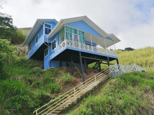una casa azul sentada en la cima de una colina en Nulu View Cabin en Kundasang