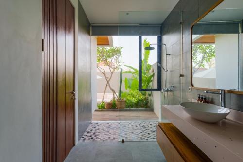 y baño con lavabo y espejo. en Villa Sagrada in Canggu Bali, en Dalung