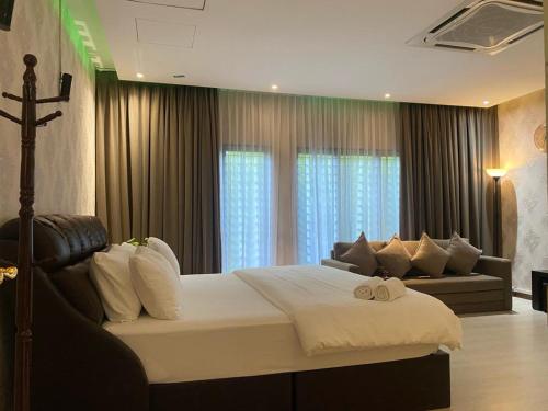 una camera con un grande letto e un divano di Aika Homestay a Shah Alam