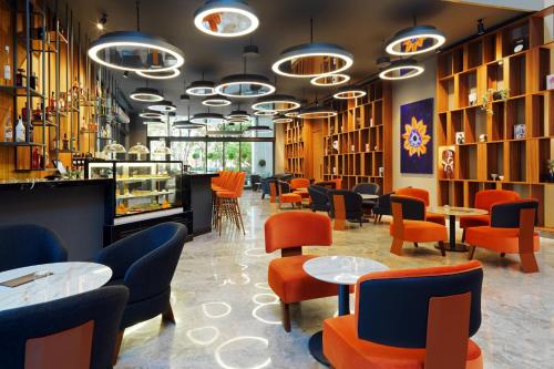 a restaurant with orange chairs and tables and chairs at Sheraton Batumi Hotel in Batumi